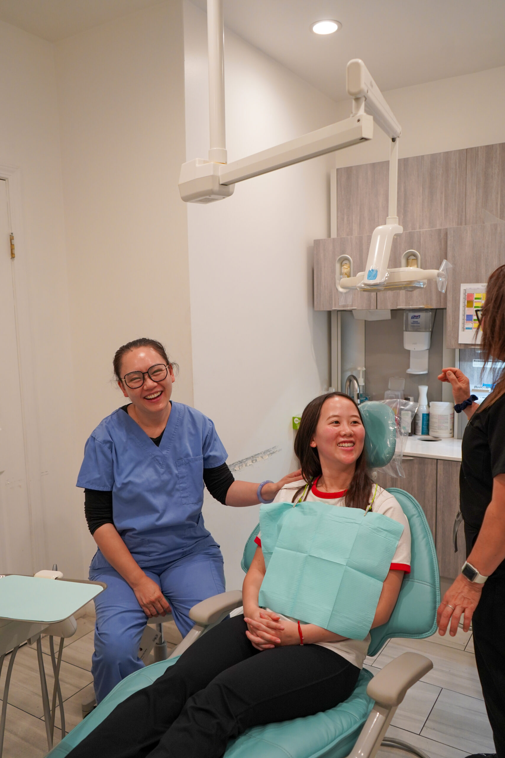 Dr. Shirley Zhao laughing with a happy patient in the dental chair at her Tracy, CA practice.